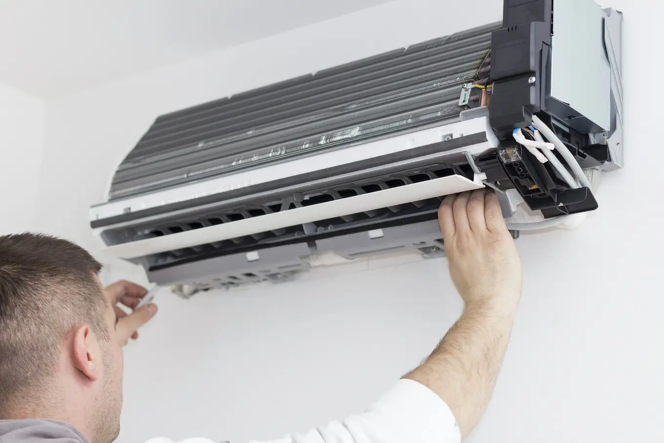 mężczyzna serwisujący klimatyzator